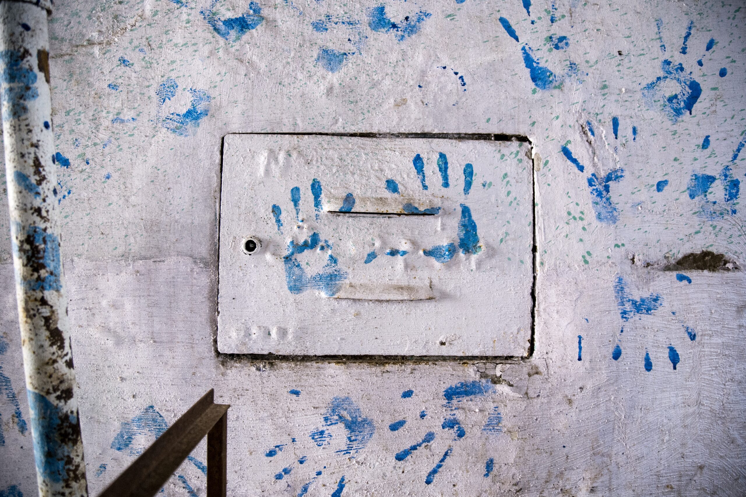 blue hand print on concrete wall